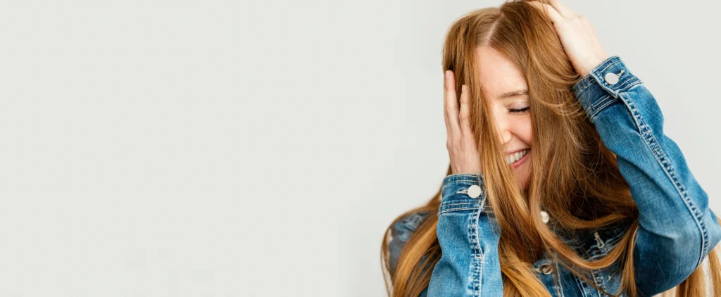 Mujer feliz con el cabello liso y brillante tras usar planchas GHD